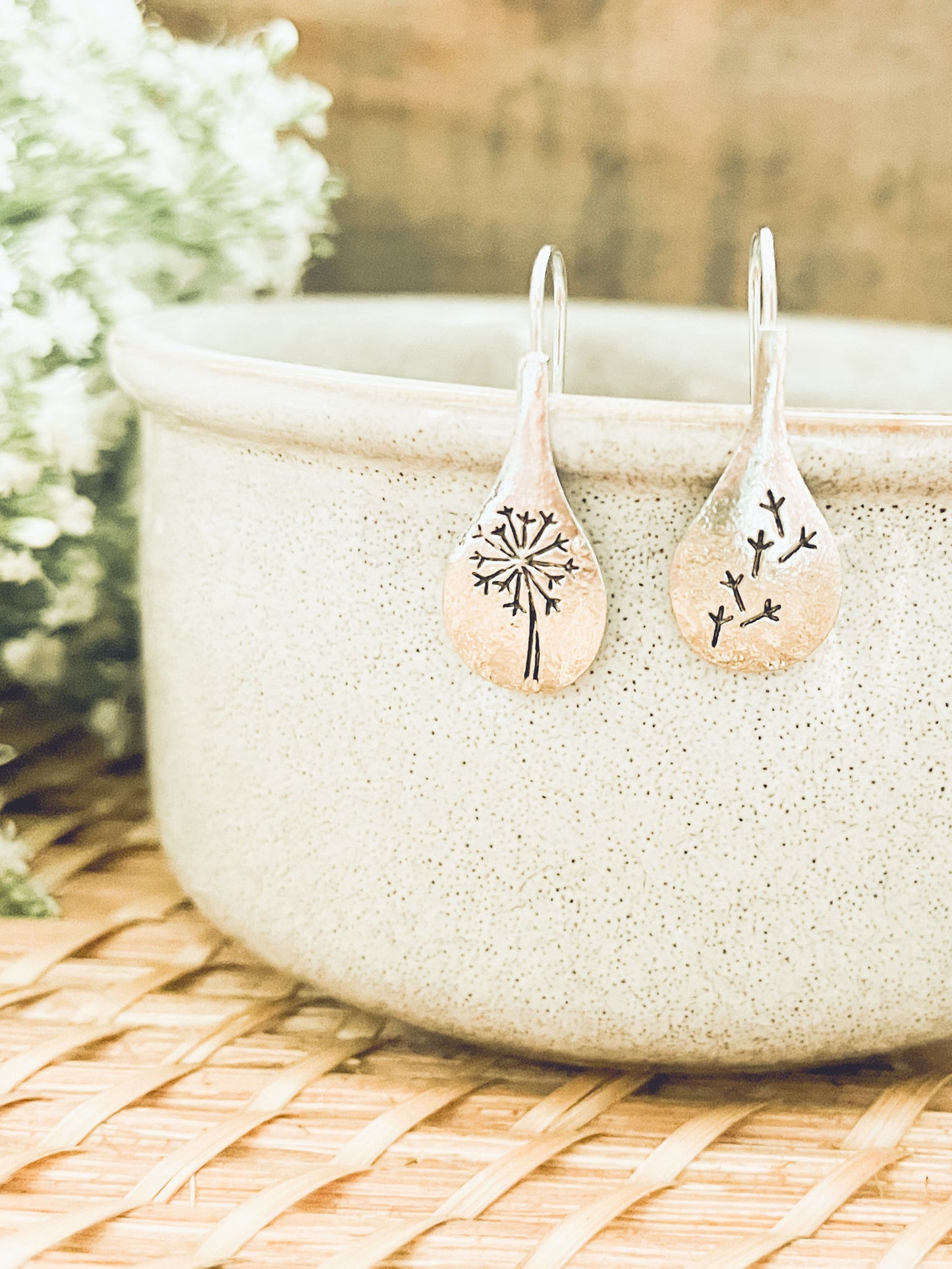 Pair of earrings with tree design on a textured surface