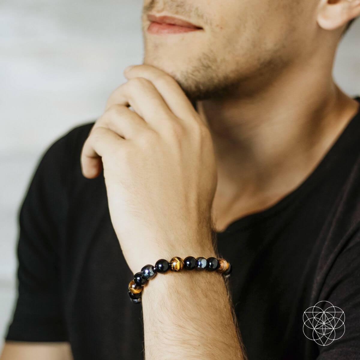 Man wearing a beaded bracelet on his wrist with a blurred background